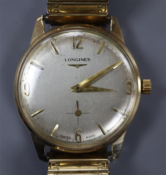 A gentlemans 9ct gold Longines manual wind wrist watch, on associated flexible strap.